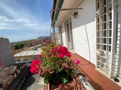 Balcony with red flowers and city view exterior at Single Bedroom in a 3-Bedroom Apartment in Rome in Rome Student Accommodation