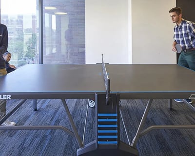 Students playing table tennis in a common area. at CampusOne in Toronto Student Accommodation