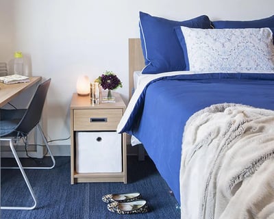 Bed nightstand desk chair and shoes bedroom at CampusOne in Toronto Student Accommodation