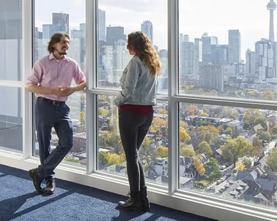 Two people looking out city view living room at CampusOne in Toronto Student Accommodation