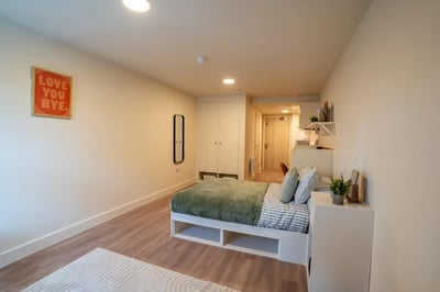 Bed with green throw mirror wardrobe bedroom at Valerian in York Student Accommodation