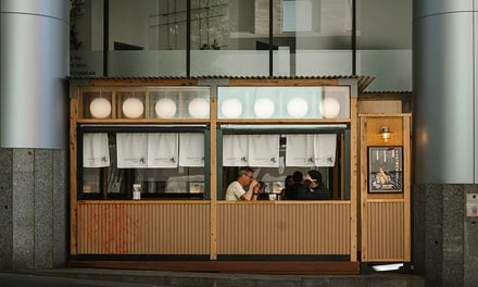 Wooden booth with customers and Japanese noren exterior at Melbourne Student Accommodation