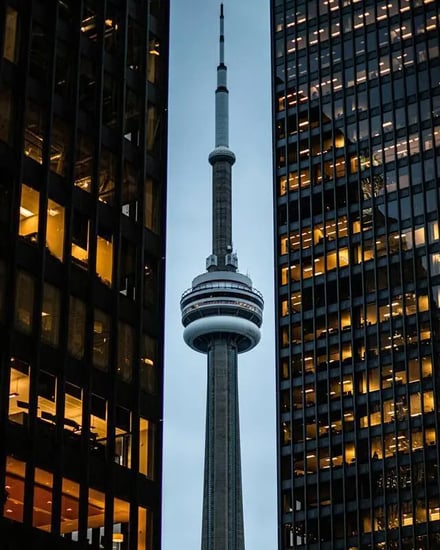 CN Tower between dark office buildings exterior at Toronto Student Accommodation