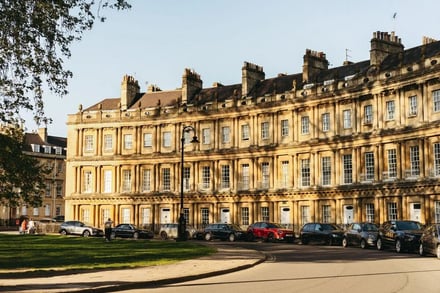 Row of cars parked along historic building exterior at Bath Student Accommodation