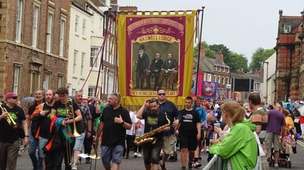 Parade banner with musicians and buildings exterior at Durham Student Accommodation
