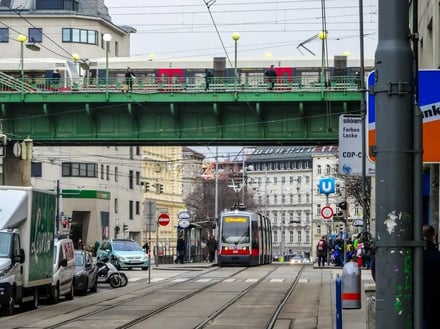 Street with tram tracks, buildings, and elevated train exterior