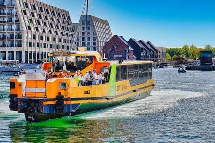 Orange ferry with passengers on water. Exterior.
