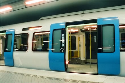 Train interior with blue doors and yellow poles transit
