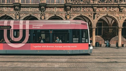Red tram with university logo exterior