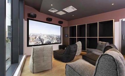 Beanbag chairs surround large screen with city view playing area at Parkway Gate in Manchester Student Accommodation