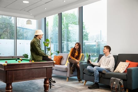 Billiard table, sofas, people, lounge area. at North Lodge in London Student Accommodation