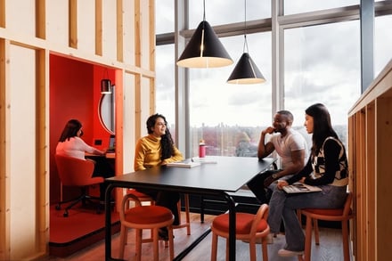 Students collaborate at a table in a communal area at Stratford One in London Student Accommodation