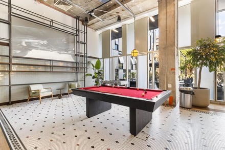 Pool table chairs plant and foosball table common area at Chapter Kings Cross in London Student Accommodation