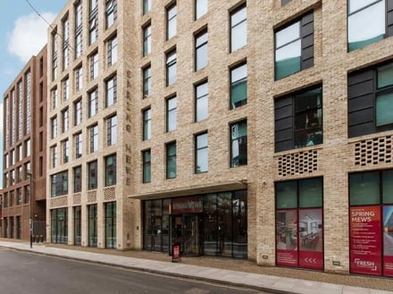Brick building with windows and entrance exterior at Spring Mews in London Student Accommodation