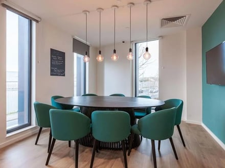 Round table and green chairs communal area living room at Pavilion Court London in Wembley Student Accommodation