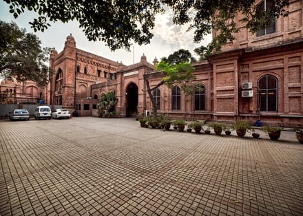 Paved courtyard with parked cars and brick building exterior at National College Of Art And Design Accommodation