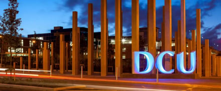 DCU sign with modern buildings at dusk exterior at Dublin City University Accommodation