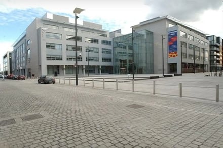 Modern building with glass entrance and parked cars exterior at National College Of Ireland Accommodation