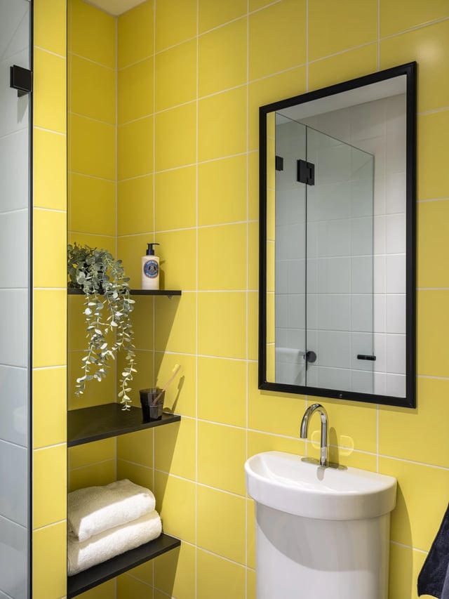 Yellow tiled bathroom with sink mirror and shelves Bathroom at UKO Newtown in Sydney Student Accommodation