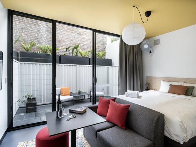 Bed with couch and outdoor patio view bedroom at UKO Newtown in Sydney Student Accommodation