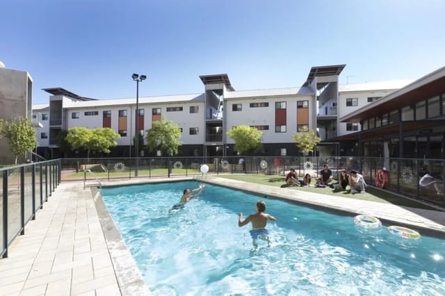 People swimming and relaxing by the pool outdoor area at ECU Villlage Mount Lawley in Perth Student Accommodation