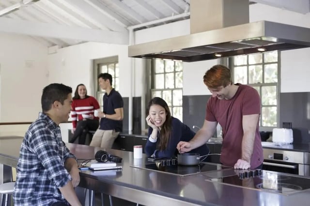 Students cooking and talking in communal kitchen kitchen at UNSW Village in Sydney Student Accommodation