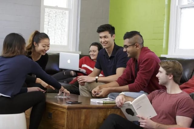 Students playing cards on sofa living room at UNSW Village in Sydney Student Accommodation