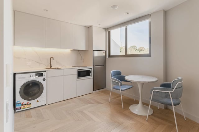 Washing machine microwave fridge table chairs kitchen at UKO Kensington in Sydney Student Accommodation