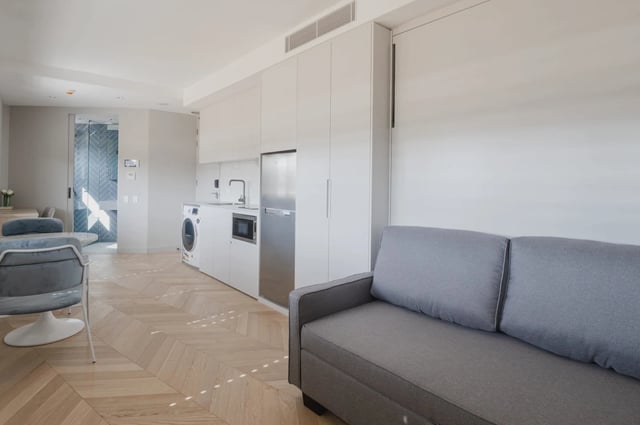Sofa kitchen appliances and washing machine living room at UKO Kensington in Sydney Student Accommodation