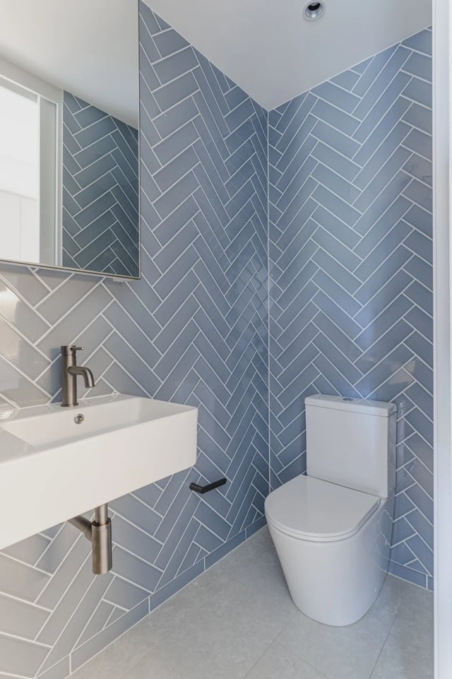 Modern bathroom with white sink toilet tiled walls at UKO Kensington in Sydney Student Accommodation