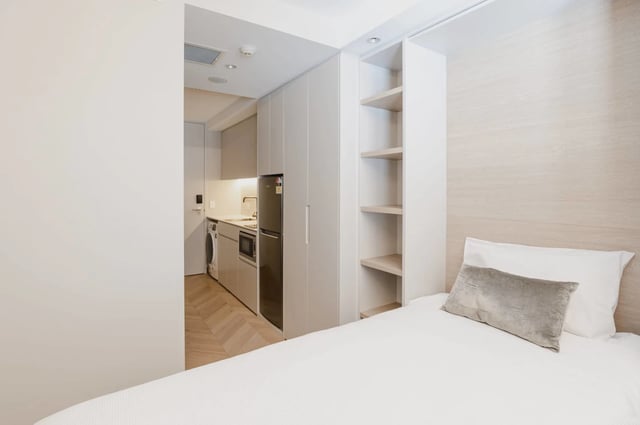 Bed kitchenette washing machine shelves bedroom at UKO Kensington in Sydney Student Accommodation