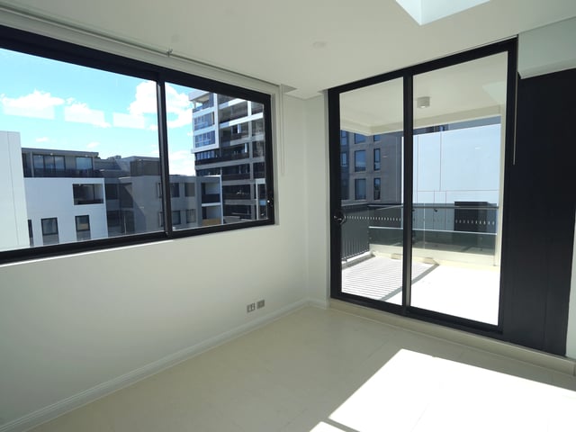 Empty room with large windows showing exterior balcony view at Belong Rosebery in Sydney Student Accommodation