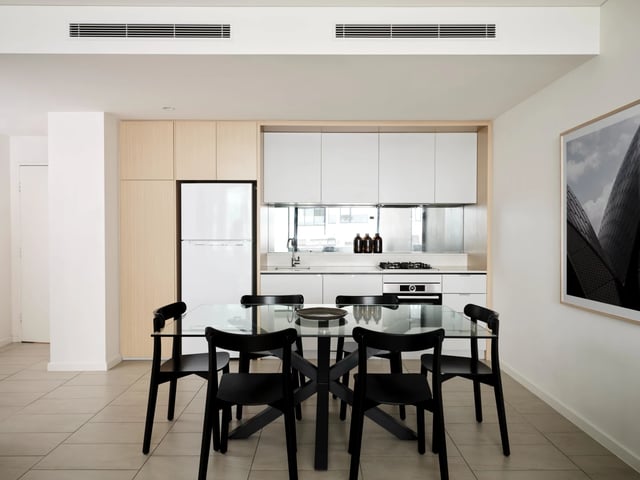 Glass dining table black chairs modern kitchen living room at UKO Camperdown in Sydney Student Accommodation
