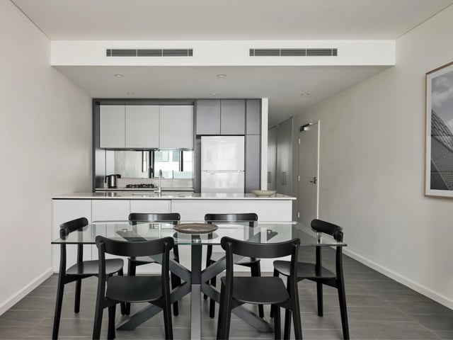 Glass dining table black chairs modern kitchen living room at UKO Camperdown in Sydney Student Accommodation