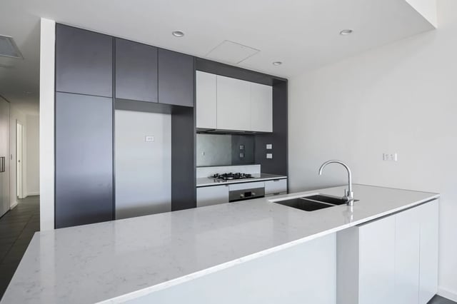 Modern grey and white kitchen with sink and stove Kitchen at UKO Camperdown in Sydney Student Accommodation
