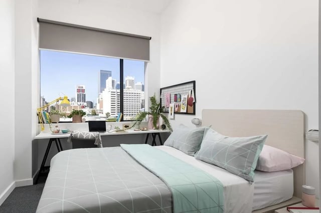 Bed desk plants window cityscape bedroom at Campus Perth in Perth Student Accommodation