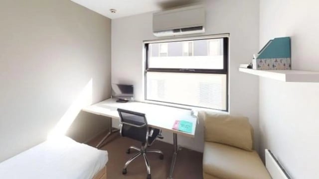 Bed desk chair sofa and air conditioner bedroom at Student Living D1 in Melbourne Student Accommodation