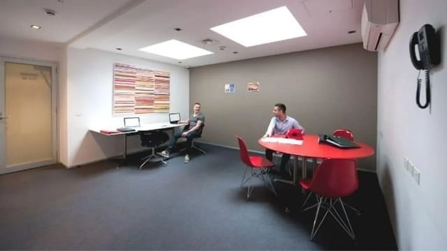 Desk laptop chairs and red table communal area at Student Living D1 in Melbourne Student Accommodation