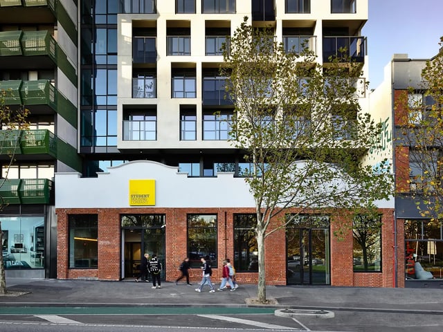 Modern building facade with people walking exterior at Yugo Berkeley Street in Melbourne Student Accommodation