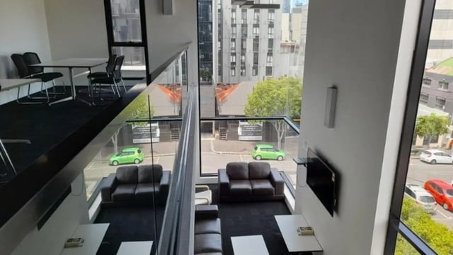 Table chairs sofas TV living area at Student Living on Villiers in Melbourne Student Accommodation