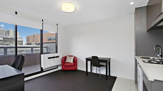 Desk red chair kitchen area living room at Student Living on Raleigh in Melbourne Student Accommodation