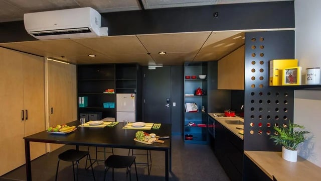 Table chairs fridge shelves and kitchen area at UniLodge @ RMIT Bundoora-Walert House in Melbourne Student Accommodation
