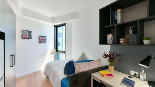 Bed with desk and shelving unit bedroom at UniLodge Toowong in Brisbane Student Accommodation