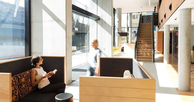 Modern seating area with woman reading living room at Iglu Chatswood in Sydney Student Accommodation