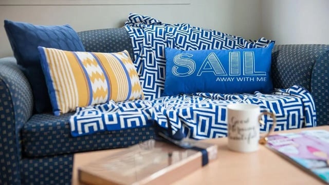 Blue sofa with patterned throw and pillows living room at Student Living-339 Swanston in Melbourne Student Accommodation