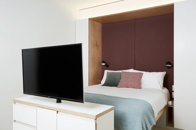 Bed dresser television and bedside table bedroom at Scape Swanston in Melbourne Student Accommodation