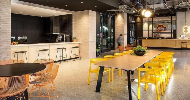Modern kitchen counter with stools communal dining table and chairs shared space at Iglu Melbourne City in Melbourne Student Accommodation