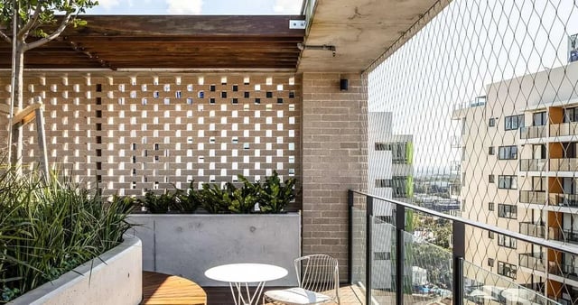 Balcony with table chairs plants and view exterior at Iglu Redfern in Sydney Student Accommodation