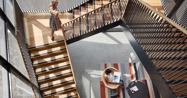 Stairs and seating area with reading person common space at Iglu Redfern in Sydney Student Accommodation