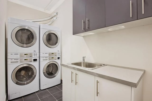Stacked washing machines and sink laundry area at Link2 Central in Sydney Student Accommodation